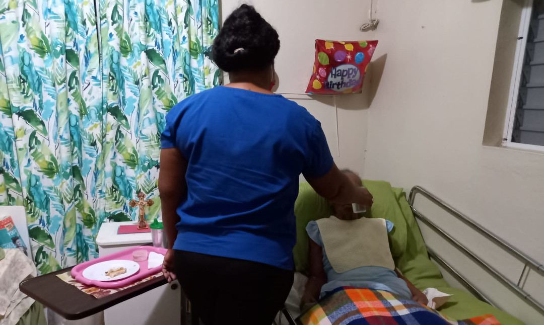 Clarkes Providers nurse feeding an elderly patient in Barbados